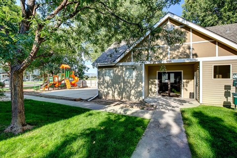 the front of a house with a yard and a playground