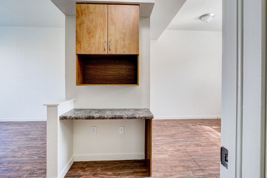 an empty living room with an island with a wooden cabinet