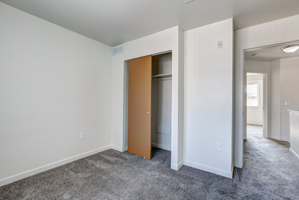 an empty living room with a door to a closet