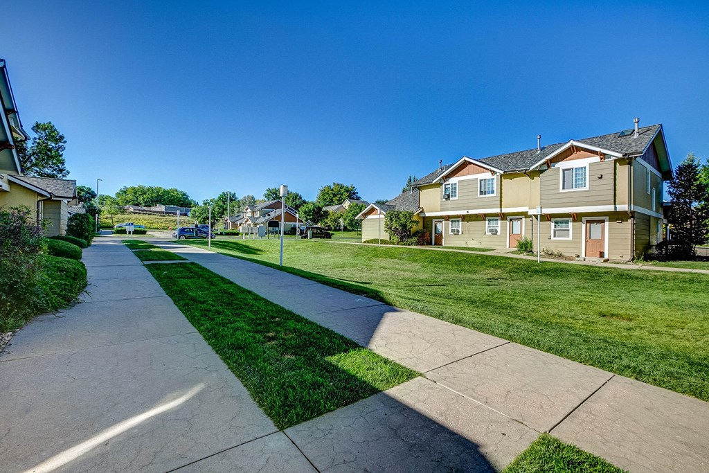 a city street with houses on either side of a sidewalk