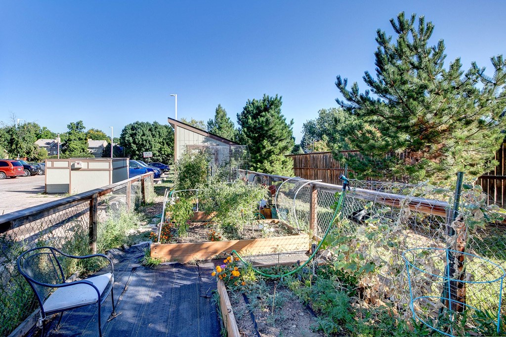 the back yard of a home with a garden and a fence
