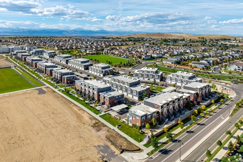 Aerial view of townhome community with mountain backdrop at Brownstones at Palisade Park Apartments, Broomfield, 80023