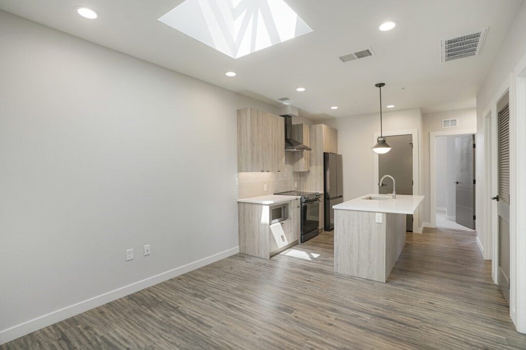 A modern kitchen with wooden floors and white walls at The Avenue Lofts Golden Apartments, Colorado