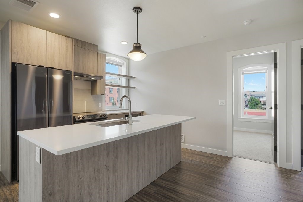 A modern kitchen with a large island and stainless steel appliances at The Avenue Lofts Golden Apartments, Golden, Colorado