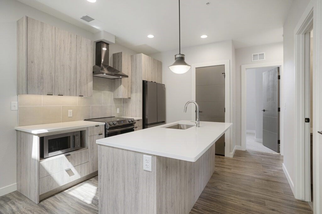 A modern kitchen with a large island and stainless steel appliances at The Avenue Lofts Golden Apartments, Golden