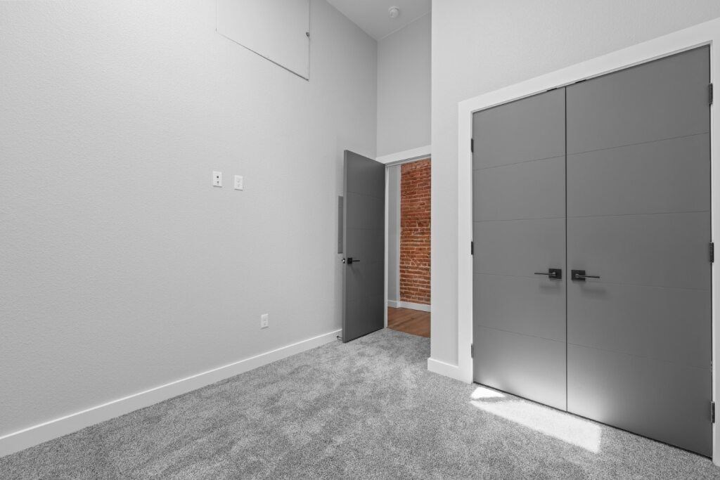 A room with a grey carpet and a grey wardrobe at The Avenue Lofts Golden Apartments, Colorado, 80401