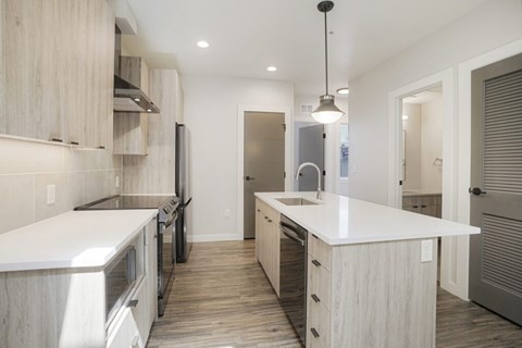 A modern kitchen with wooden cabinets and a white countertop.