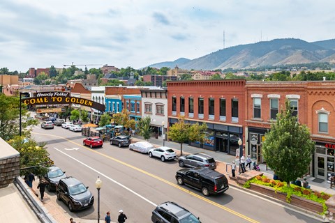 A street view of a town with cars and buildings.