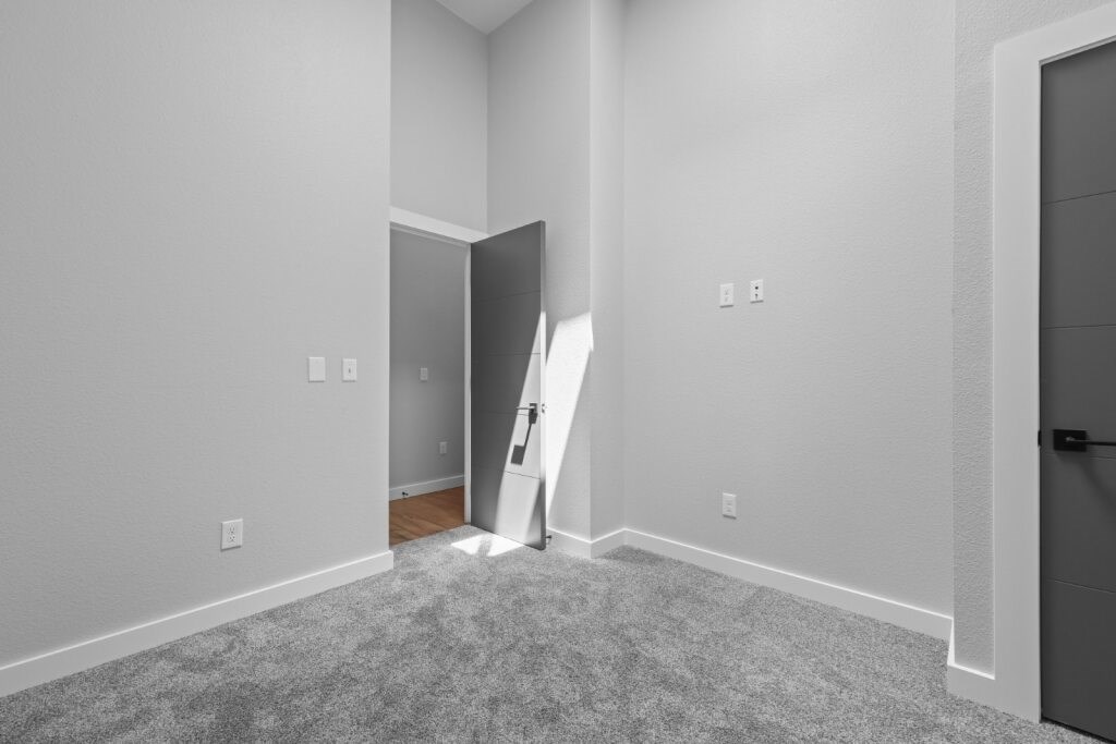 A room with a grey carpet and a white door at The Avenue Lofts Golden Apartments, Golden 80401