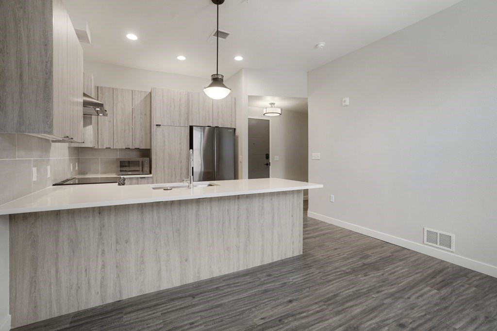 A modern kitchen with a wooden countertop and stainless steel appliances at The Avenue Lofts Golden Apartments, Golden
