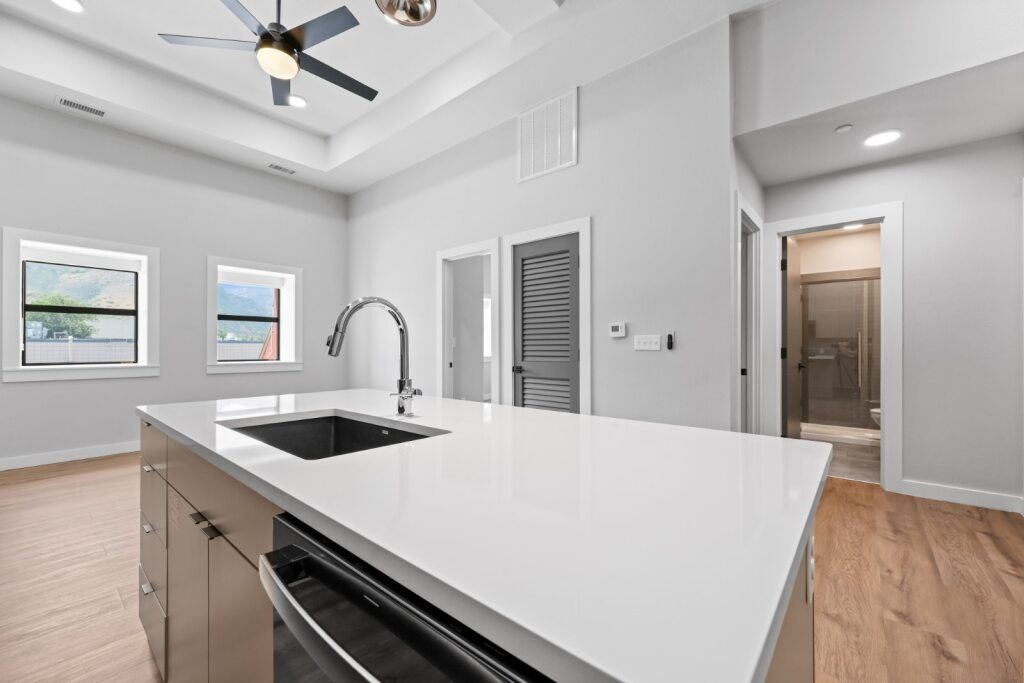 A modern kitchen with a white countertop and stainless steel appliances at The Avenue Lofts Golden Apartments, Golden 80401