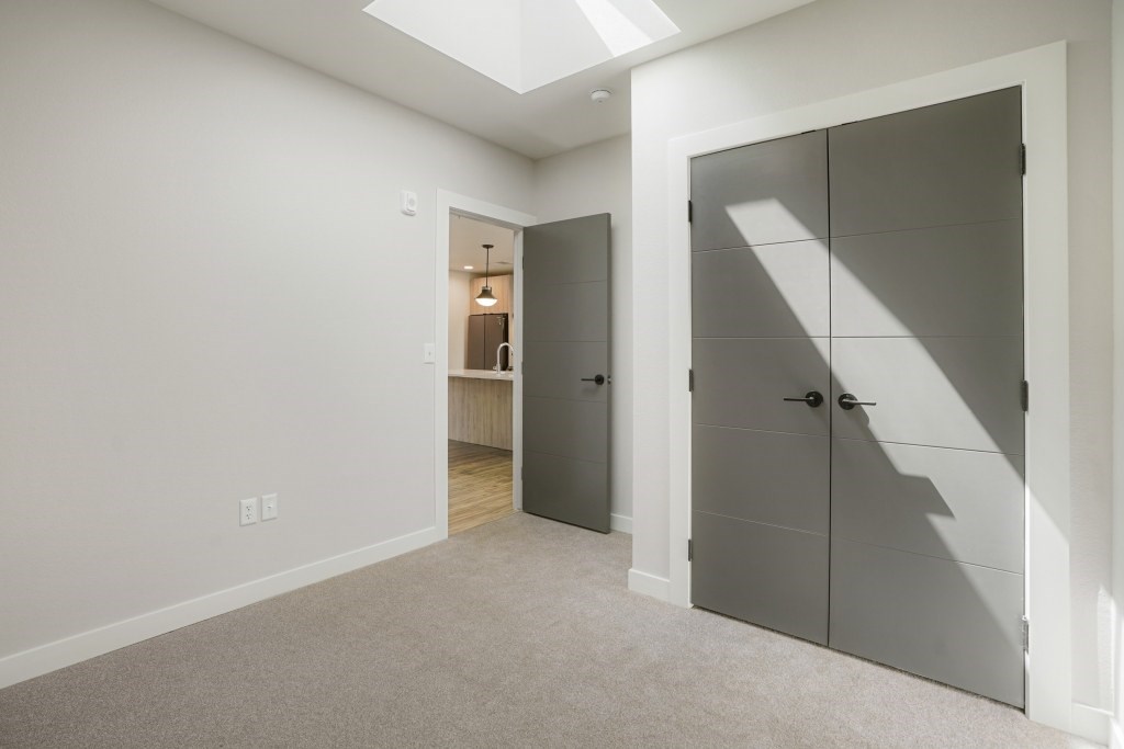 A room with a grey carpet and a grey wardrobe at The Avenue Lofts Golden Apartments, Golden, CO