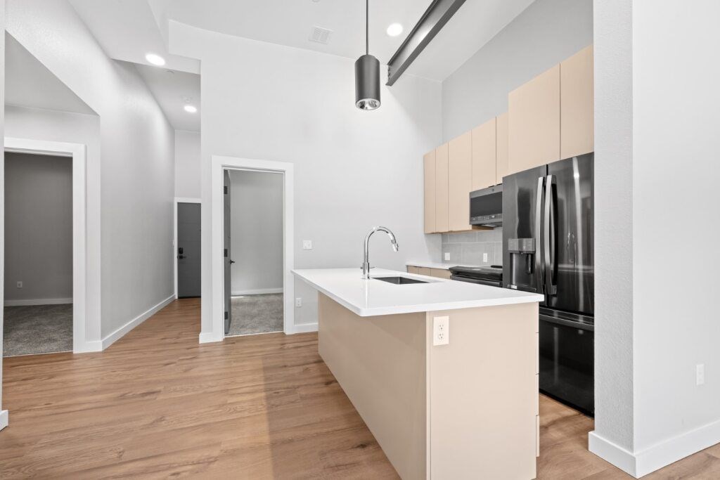 A kitchen with a sink and a refrigerator at The Avenue Lofts Golden Apartments, Colorado