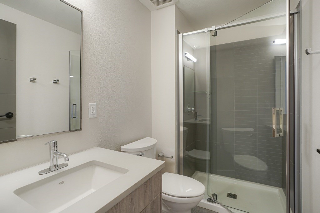 A modern bathroom with a sink, toilet, and shower at The Avenue Lofts Golden Apartments, Colorado, 80401