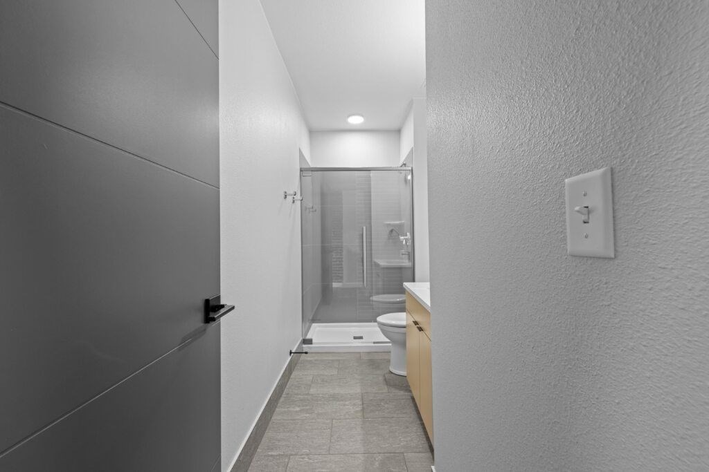 A bathroom with a walk-in shower and a toilet at The Avenue Lofts Golden Apartments, Golden, CO