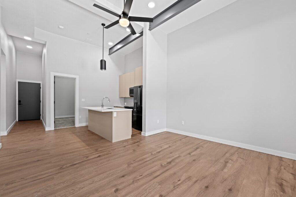 A room with a ceiling fan and a kitchenette at The Avenue Lofts Golden Apartments, Colorado, 80401