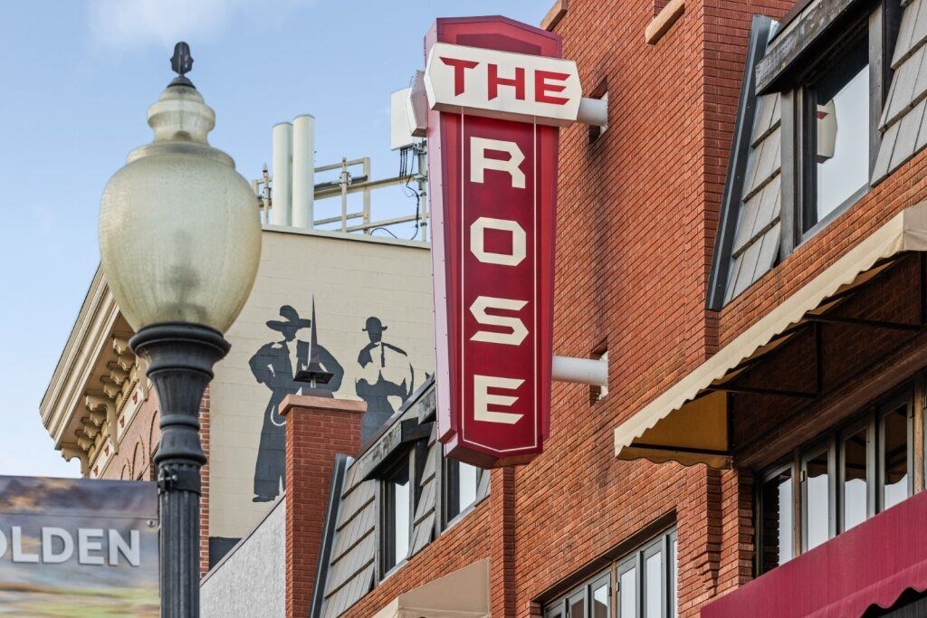 The Rose is a red building with a sign on it at The Avenue Lofts Golden Apartments, Colorado
