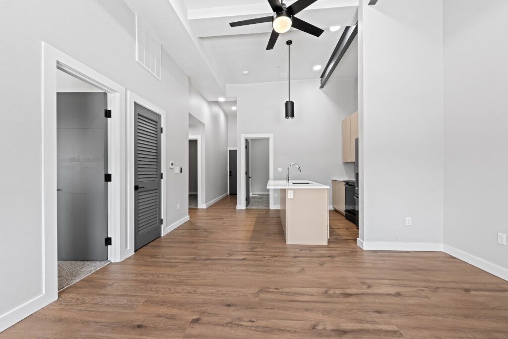 A long, empty hallway with a ceiling fan and wooden floors at The Avenue Lofts Golden Apartments, Golden, CO, 80401