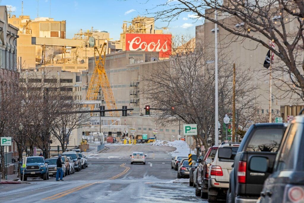 A Coors sign is on a building in a city at The Avenue Lofts Golden Apartments, Golden