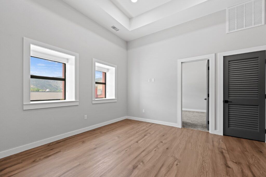 A room with wooden floors and two windows at The Avenue Lofts Golden Apartments, Colorado