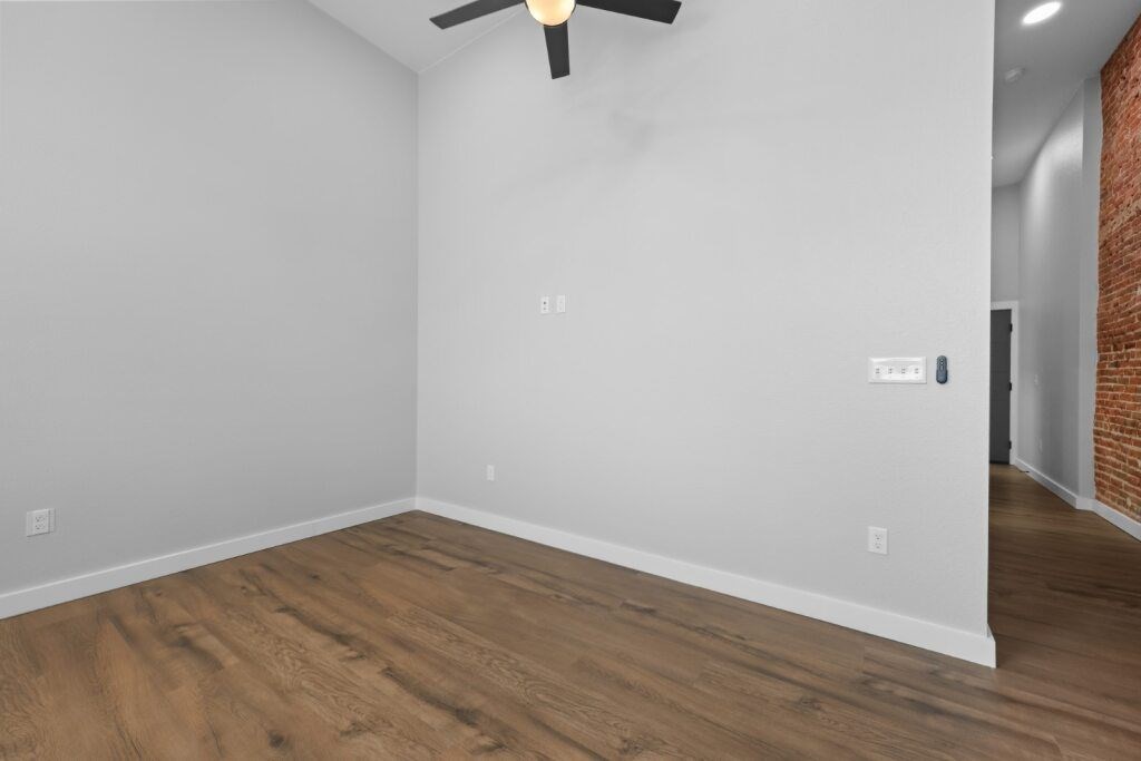 A room with a ceiling fan and wooden flooring at The Avenue Lofts Golden Apartments, Golden, CO, 80401