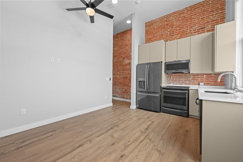 A kitchen with a brick wall and wooden floors at The Avenue Lofts Golden Apartments, Golden