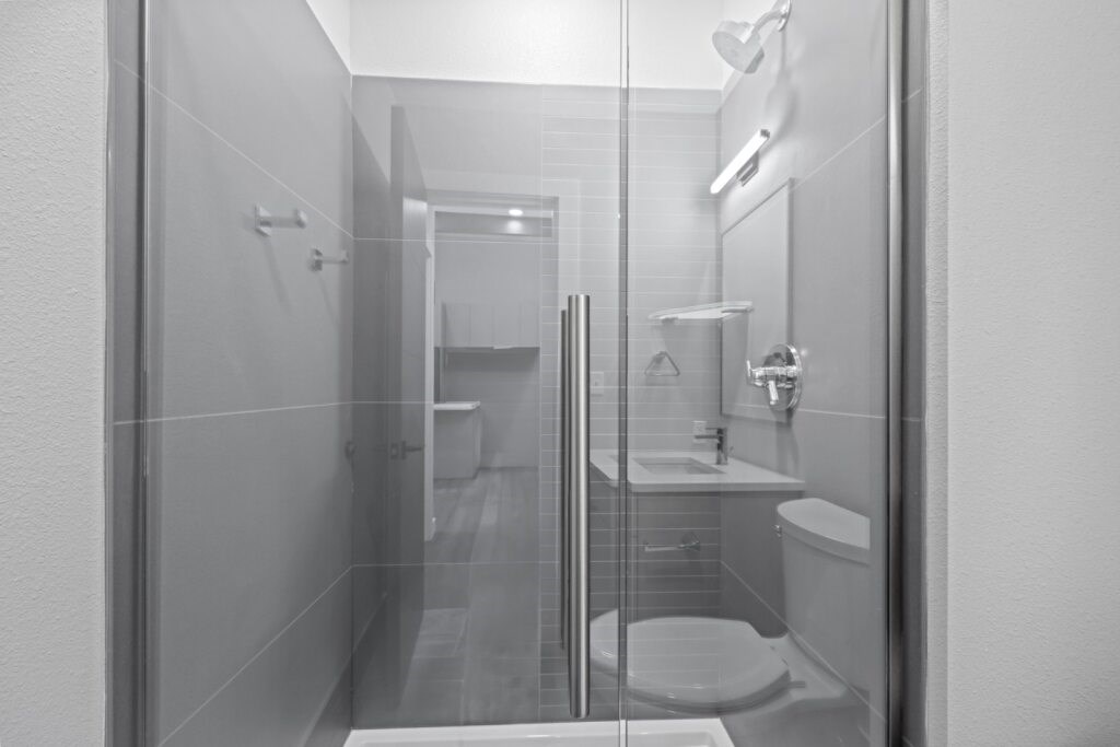 A bathroom with a toilet, sink, and shower at The Avenue Lofts Golden Apartments, Colorado