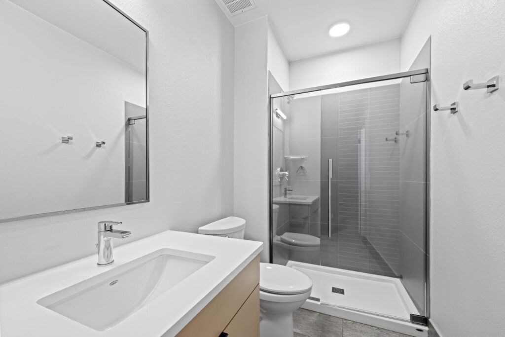 A modern bathroom with a white sink and a walk-in shower at The Avenue Lofts Golden Apartments, Golden