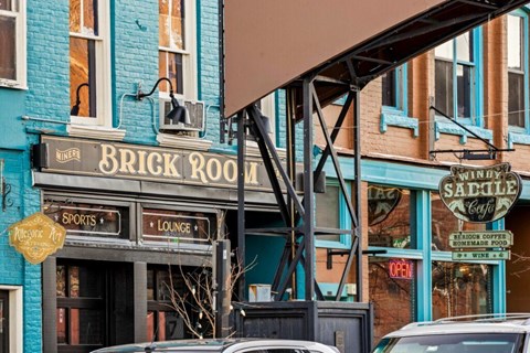 Downtown storefronts with overhead pedestrian bridge at The Avenue Lofts Golden Apartments, Golden, CO