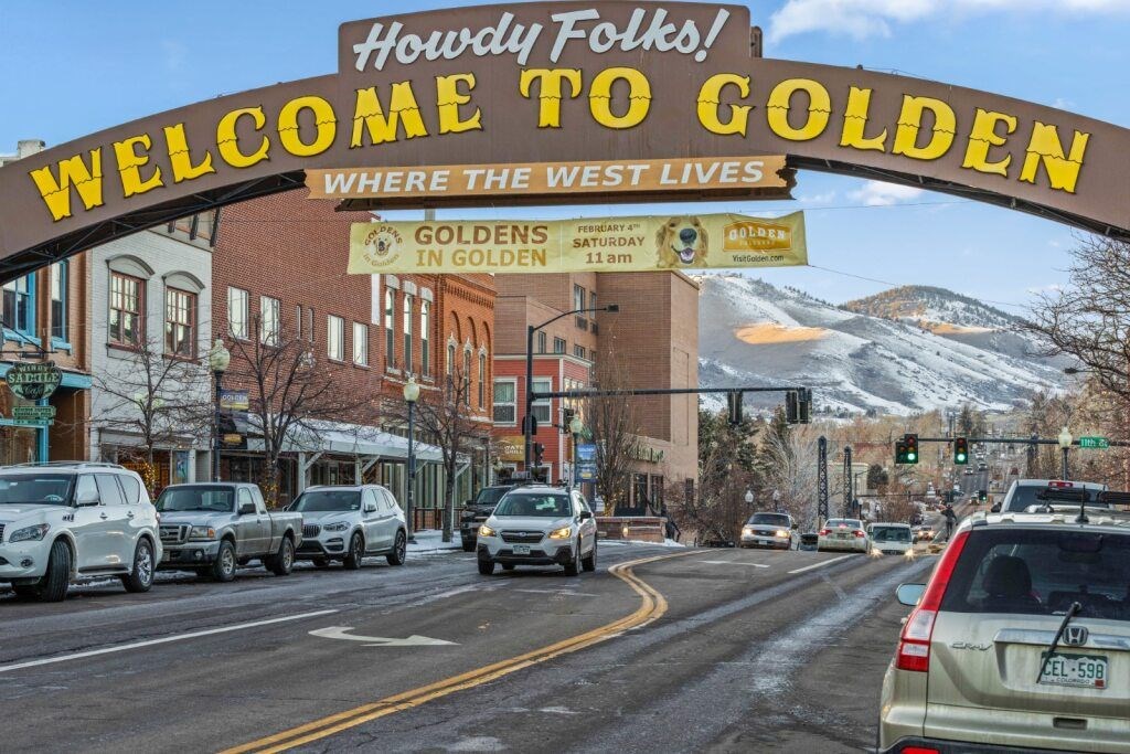 A sign welcoming people to Golden with a mountain in the background at The Avenue Lofts Golden Apartments, Golden 80401