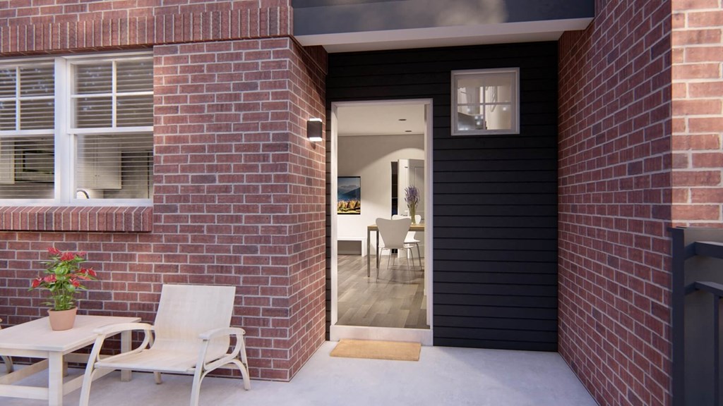 this house has a black exterior with a red brick wall at Brownstones at Palisade Park, Broomfield, CO