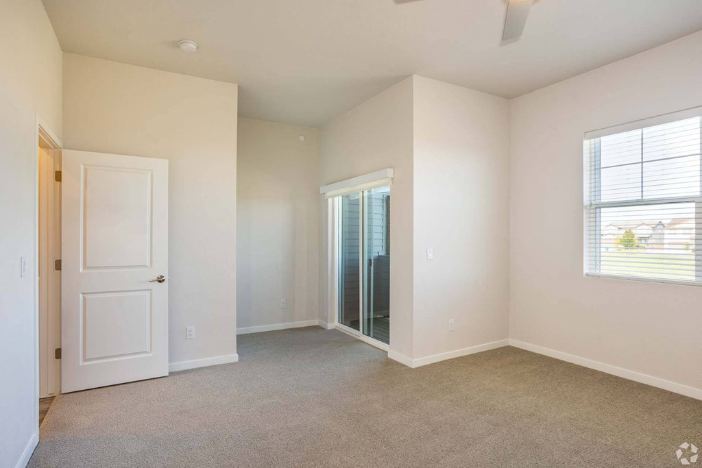 bedroom with doors leading to patio at Palisade Park Townhomes, Broomfield Colorado