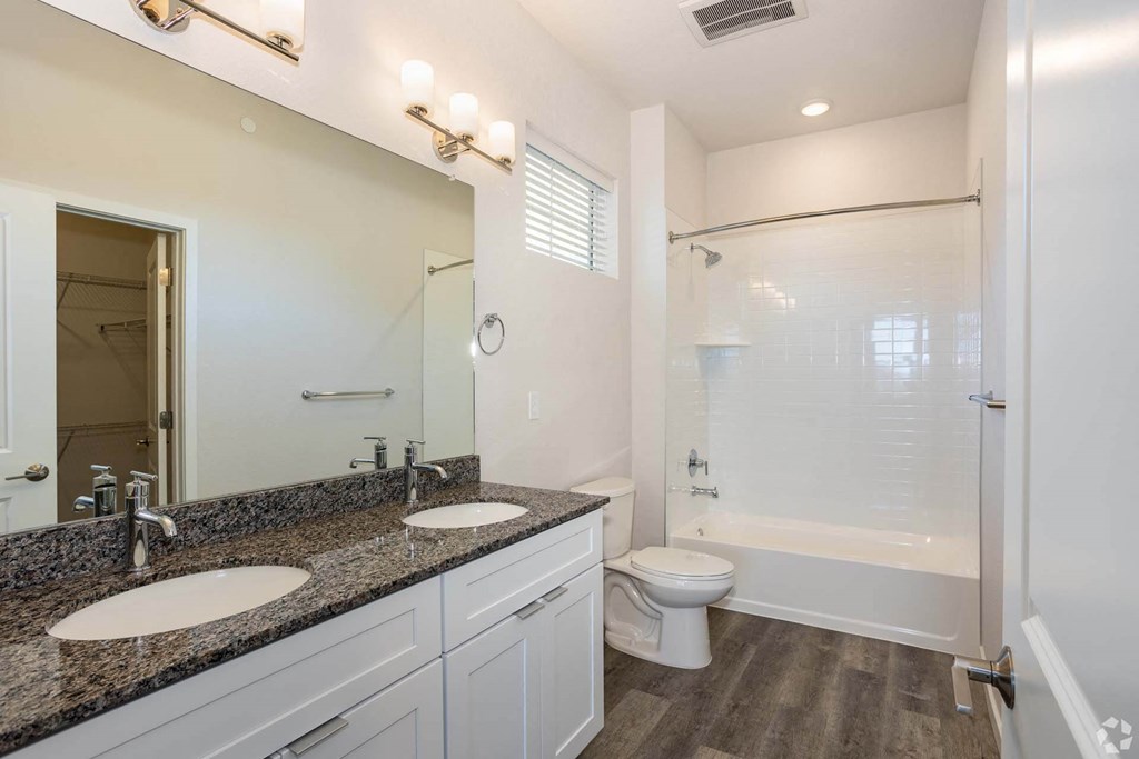 dual vanity bathroom with toilet and white tub at Palisade Park Townhomes, Colorado, 80023