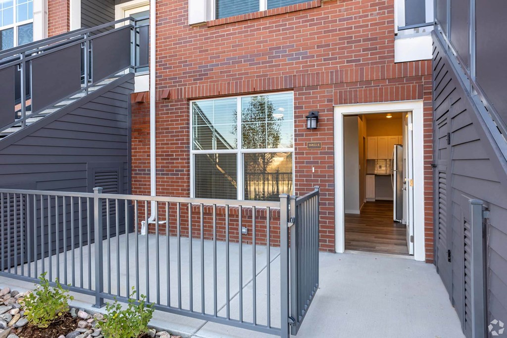 exterior view of a patio and brownstone building at Brownstone at Palisade Park, Broomfield