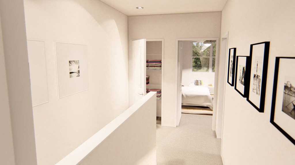 a long white hallway with pictures on the wall at Brownstones at Palisade Park, Colorado, 80023