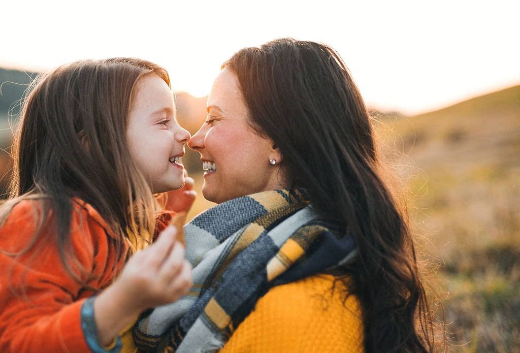 a mother and daughter smiling at each other at Brownstones at Palisade Park Townhomes, Broomfield, 80023
