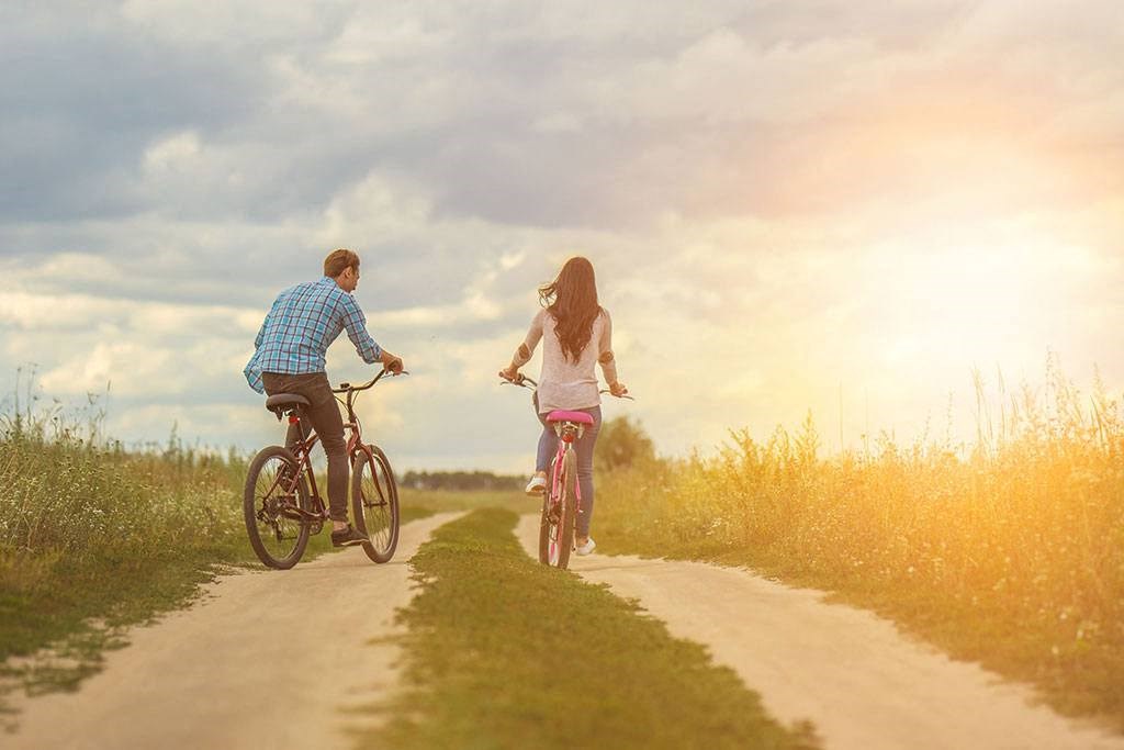 a man and a woman riding bikes down a dirt road at Brownstones at Palisade Park Townhomes, Broomfield, CO
