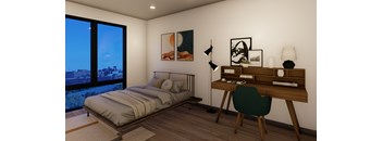A bedroom with a bed, desk, and chair.