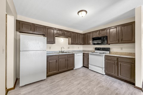 A kitchen with brown cabinets and a white refrigerator.