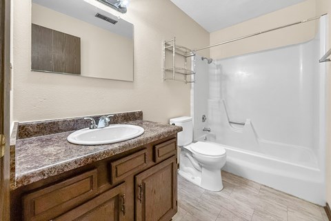 A bathroom with a sink, toilet, and bathtub.