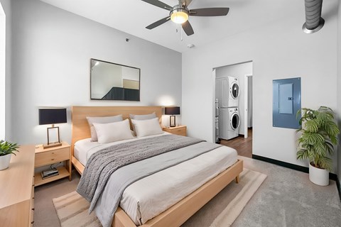 A bedroom with a bed, nightstand, and a ceiling fan.
