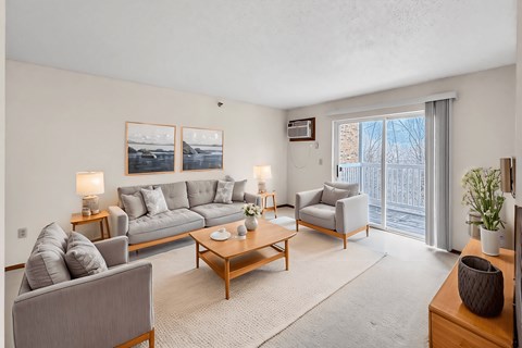 A living room with a grey couch, a coffee table, and a painting on the wall.
