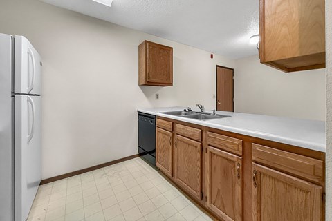 A kitchen with wooden cabinets and a white fridge.