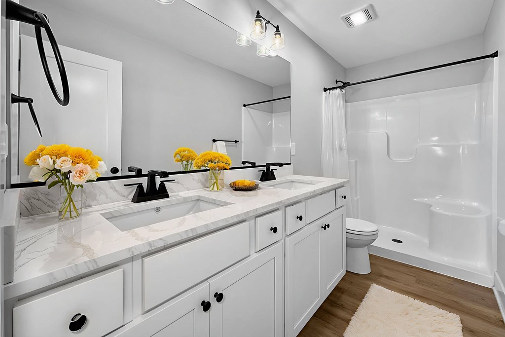 A bathroom with a white sink and a white toilet.