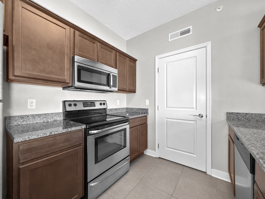 A kitchen with brown cabinets and a white door.