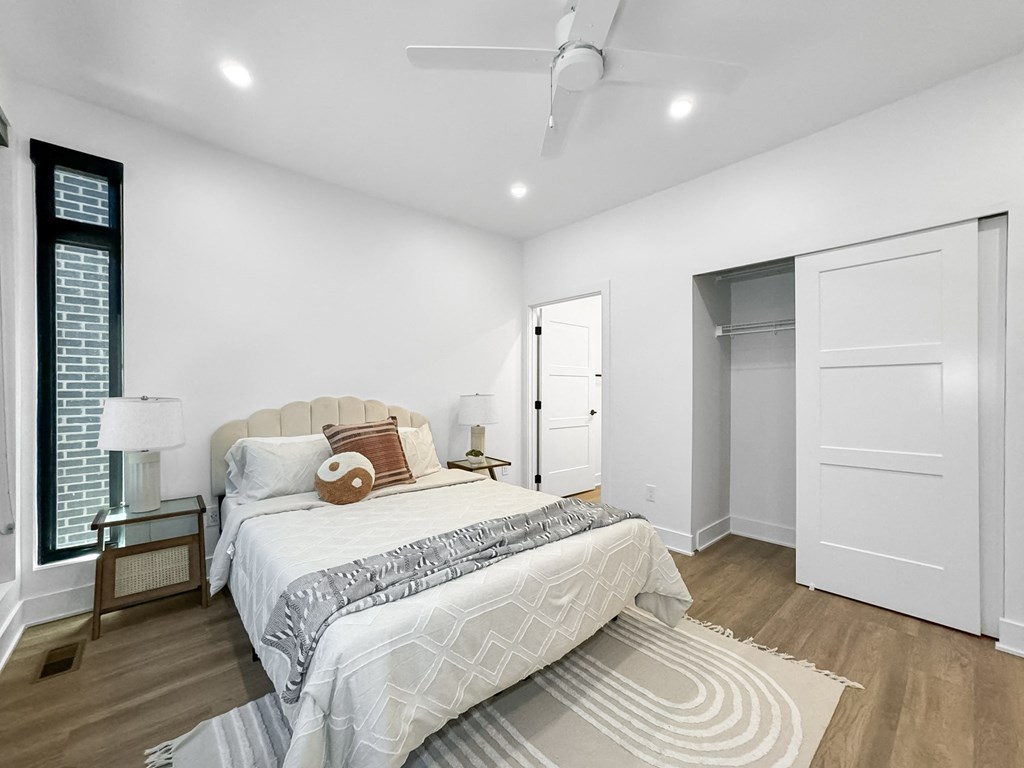 a white bedroom with a large bed and white closets