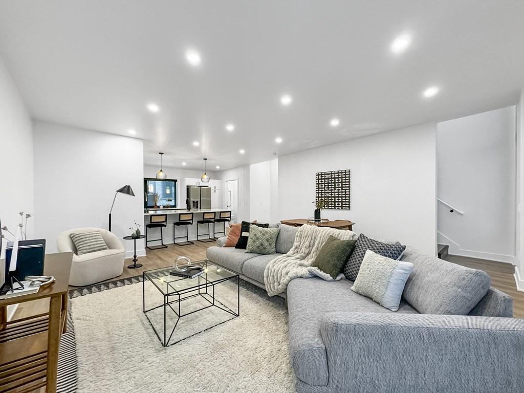 a living room with a gray couch and a glass coffee table