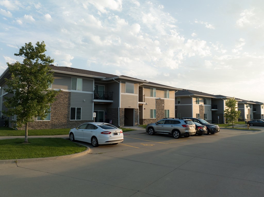 A white car is parked in front of a building.