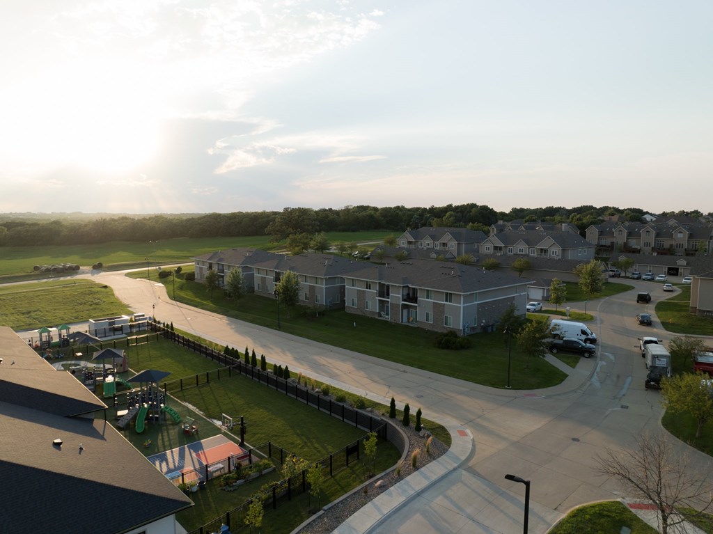 A sunny day in a residential area with houses and cars.