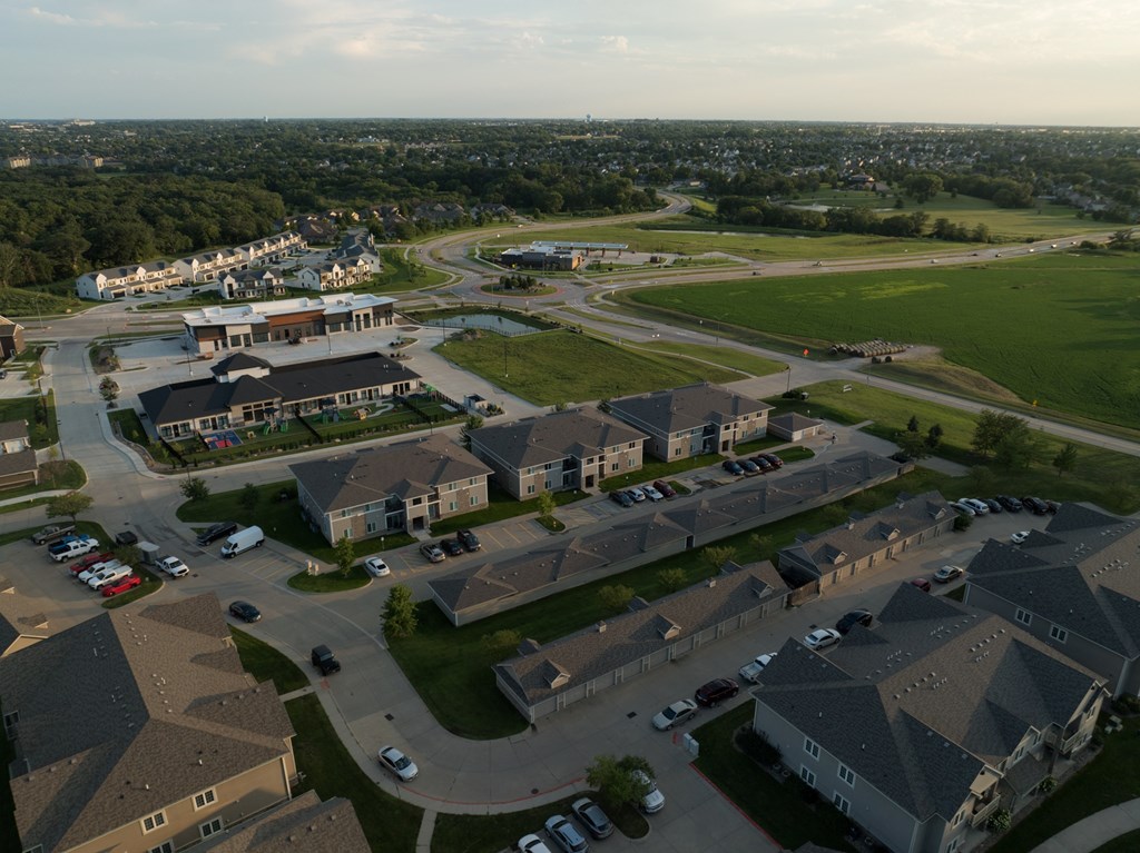 A large aerial view of a residential area with houses and a parking lot.